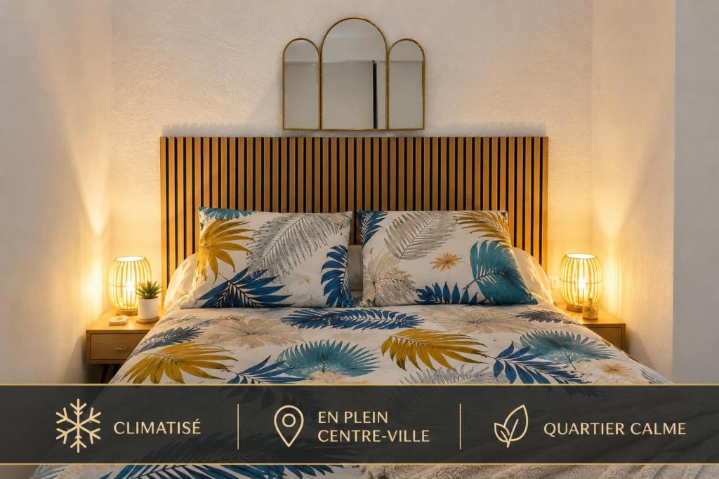 a bed with blue and white sheets and pillows at Appartement charmant au cœur de Saint-Rémy, idéal pour une escapade provençale ! in Saint-Rémy-de-Provence