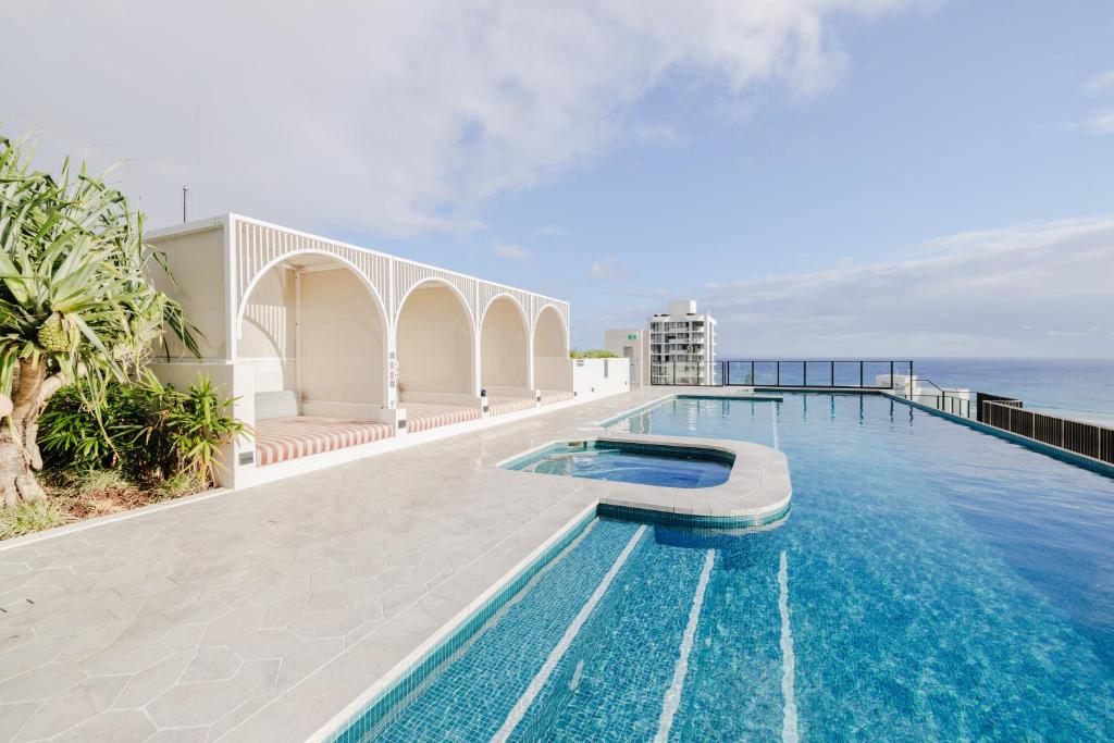 a swimming pool with a view of the ocean at Esprit Holidays Rainbow Bay in Gold Coast
