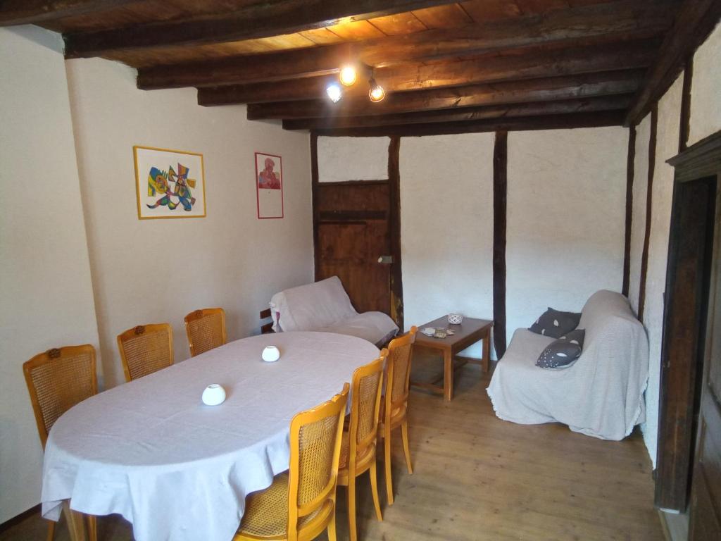 a dining room with a white table and chairs at Les Coquillages in Essoyes