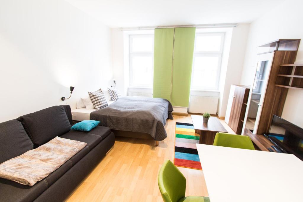ein Wohnzimmer mit einem Sofa und einem Bett in der Unterkunft Apartment Knöllgasse in Wien