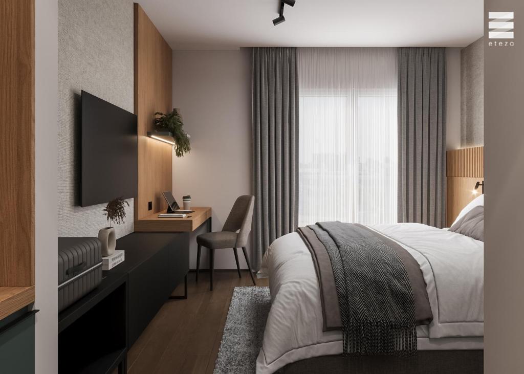 a bedroom with a bed and a desk with a television at Tailormade Hotel Median Niš in Niš