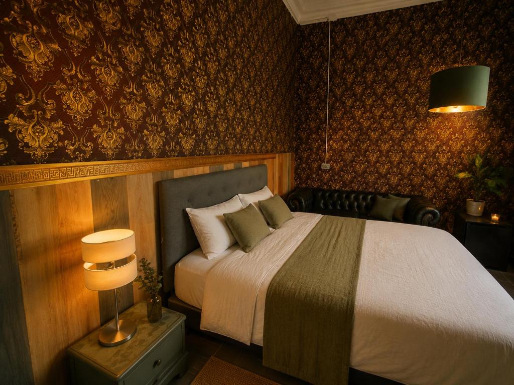 a bedroom with a large bed and a lamp at Downtown Guest house in Santiago