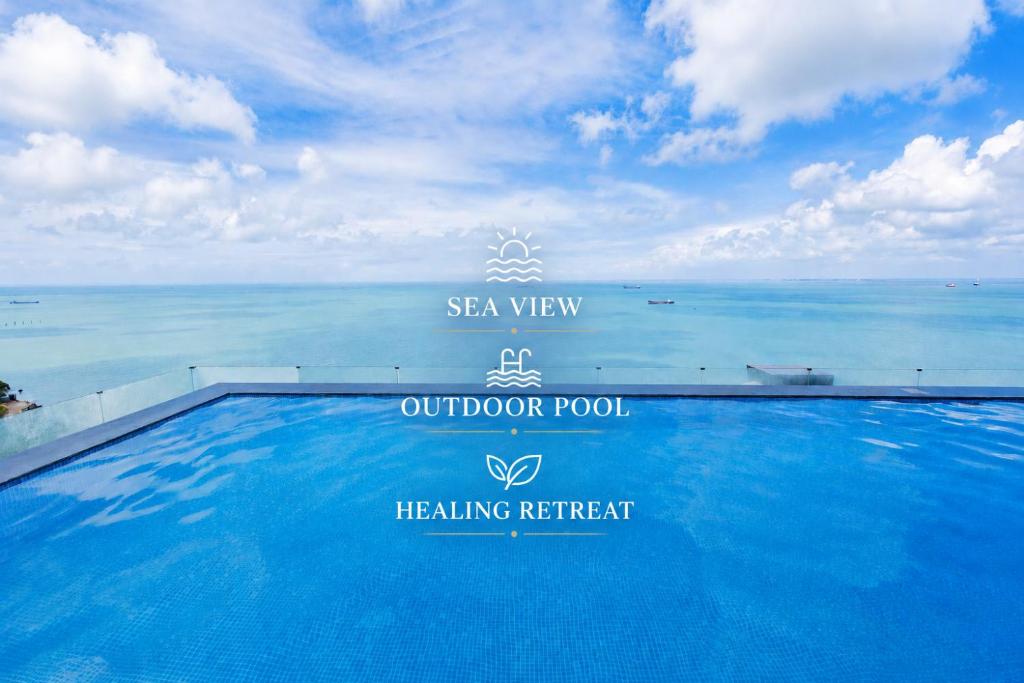 a swimming pool with the ocean in the background at Oyster Bay Vũng Tàu - Seaside Pool Escape in Vung Tau