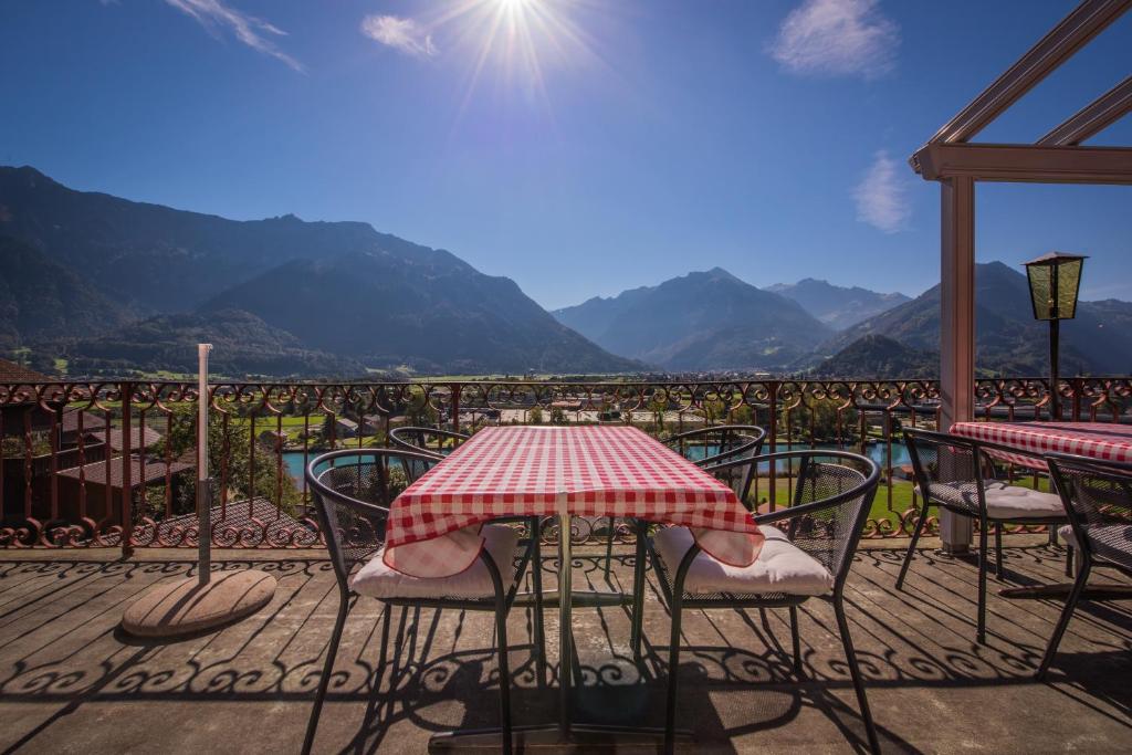 a table and chairs on a balcony with a view of mountains at Gasthof Schoenegg B&B in Goldswil