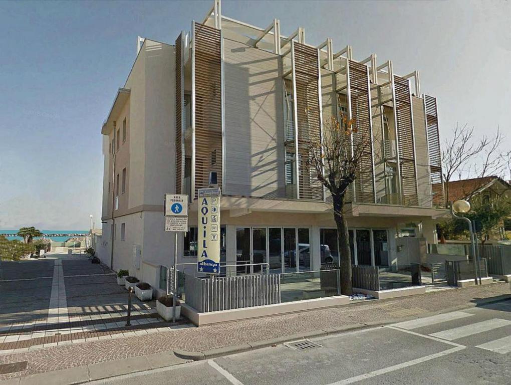 un grande edificio sul lato di una strada di Albergo Aquila a Rimini