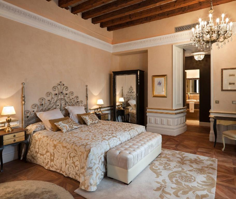 a bedroom with a large bed and a chandelier at Hotel Casa 1800 Sevilla in Seville