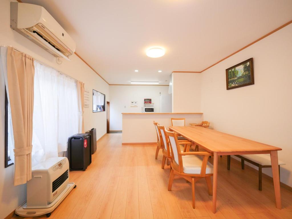 a dining room with a wooden table and chairs at 雪の宿 in Numata