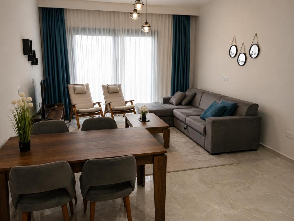 a living room with a couch and a table and chairs at Rıversıdelıfe Iskele M 147 in Aglantzia