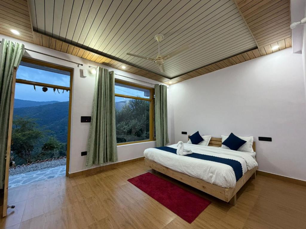 a bedroom with a bed and a large window at Pahadi Aangan Chakrata in Kailāna