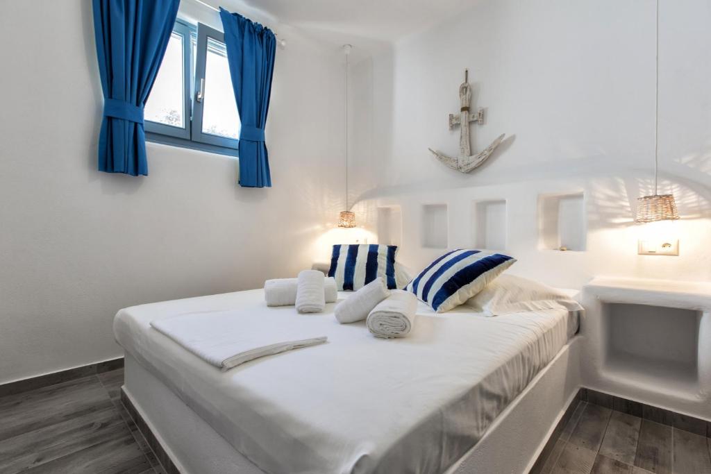 een slaapkamer met een bed met blauwe gordijnen en een wastafel bij Casa Perla in Mikri Vigla