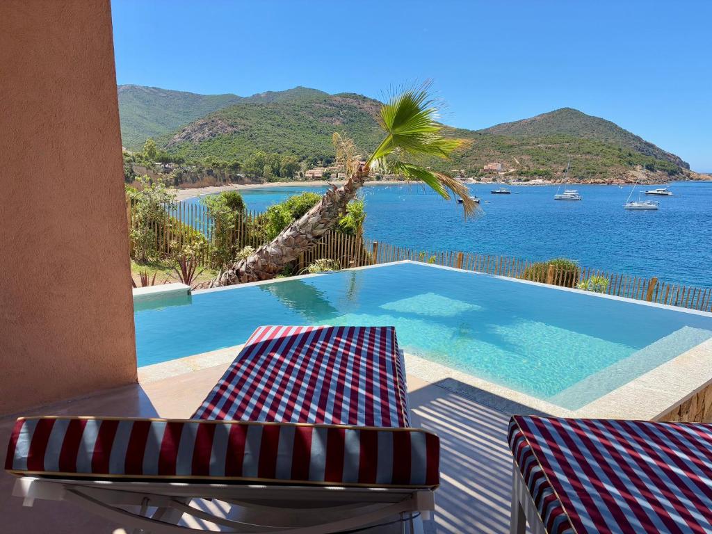 a pool with two chairs and a view of the ocean at Alpa Nera in Galeria