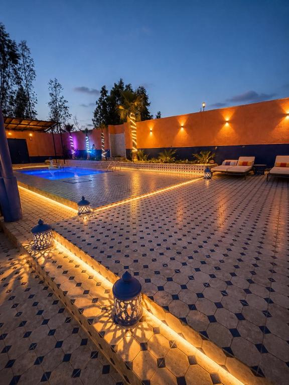 a swimming pool with lights in the middle at night at villa Oasis Rouge Sable in Marrakesh