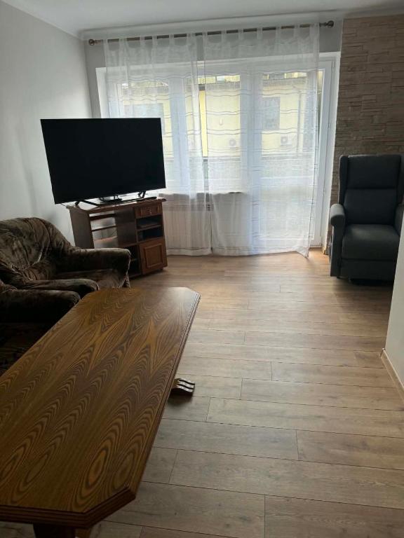 a living room with a flat screen tv and a table at Wygodny kąt in Tarnobrzeg