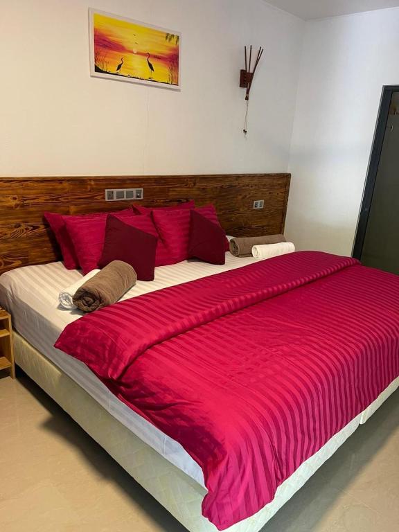 a large bed with a red blanket on it at Zukara Maldives in Thoddoo