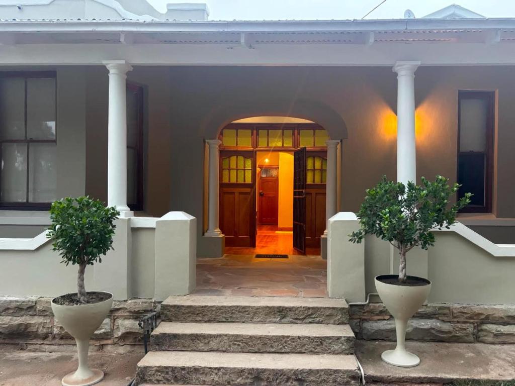 a front door of a house with two potted trees at River and Ridge in Cradock
