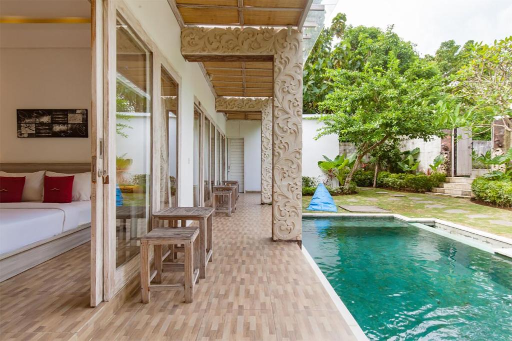 a villa with a bed and a swimming pool at Nyang-Nyang Retreat in Uluwatu