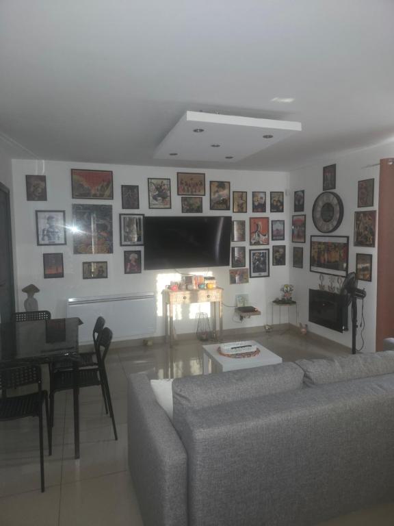 a living room with a couch and a tv at maison entre Disneyland et Paris in Meaux