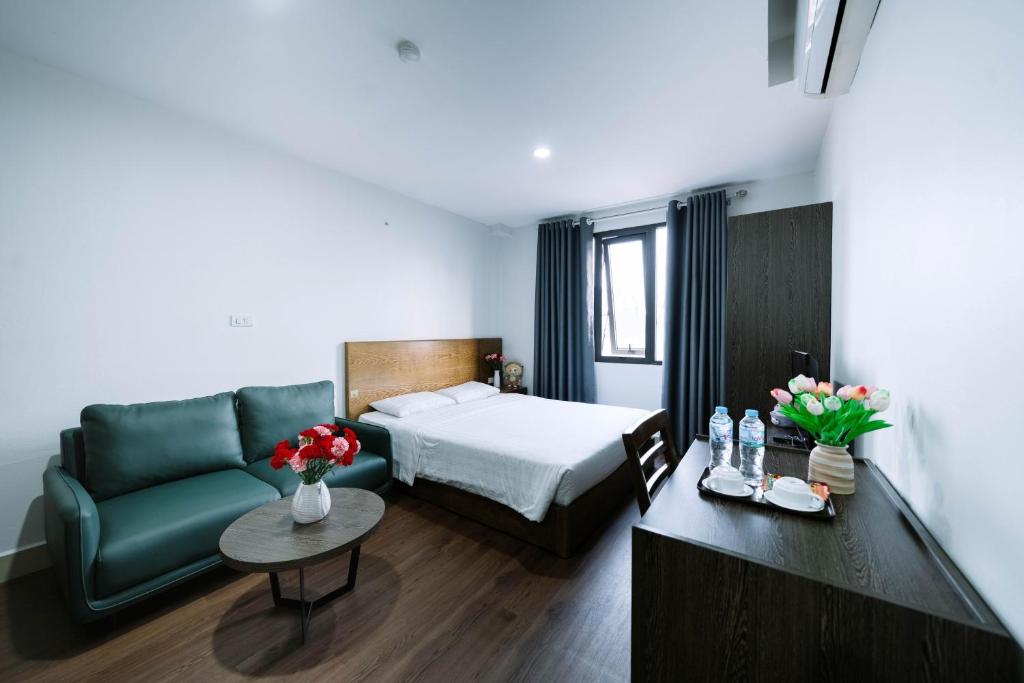 a hotel room with a bed and a couch at Granda Hanoi Hotel & Apartment in Hanoi