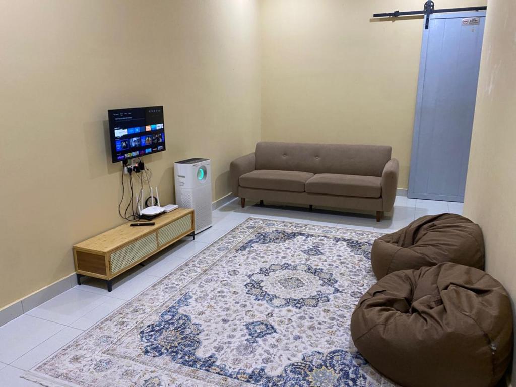 a living room with a couch and a tv at Rumah Inap Nik Atik in Cukai