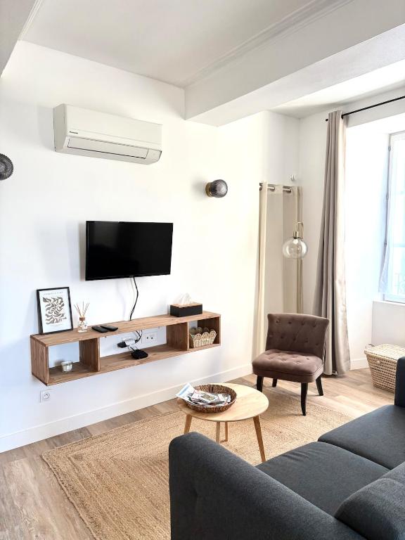 a living room with a tv on a white wall at appartement mauléon in Mauléon