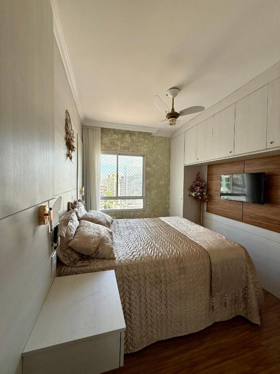 a bedroom with a bed and a ceiling fan at Apartamento Praia da Costa in Vila Velha