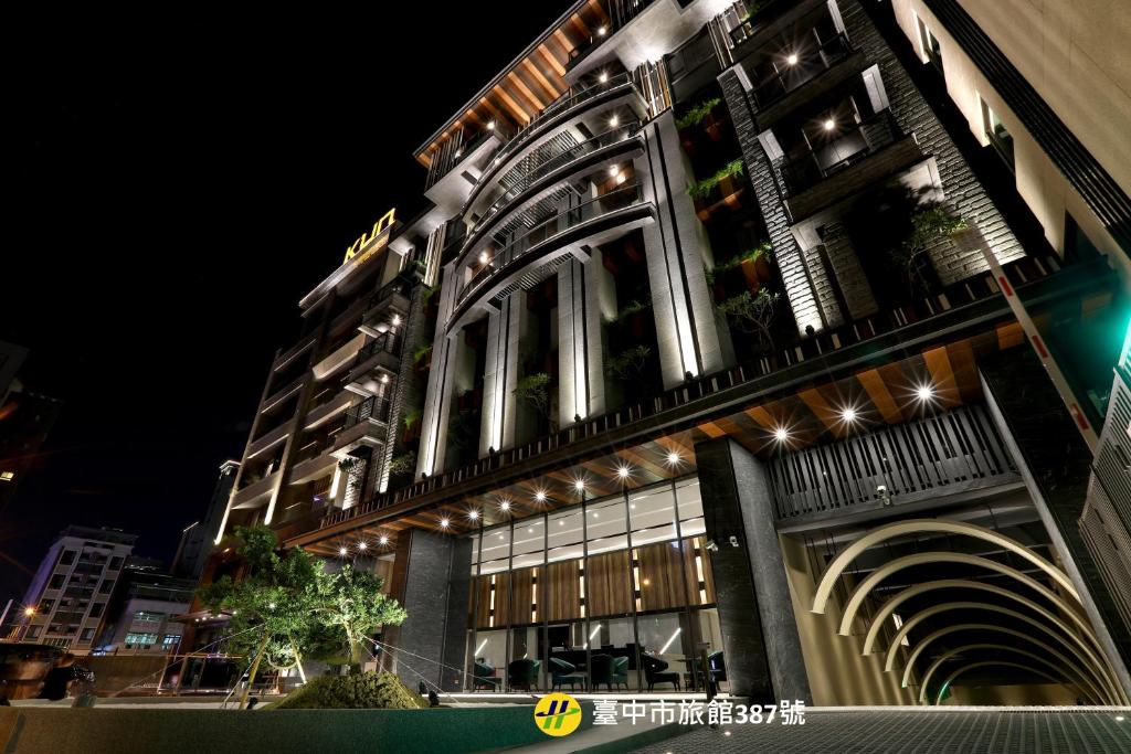 a large building with lights on it at night at Kun Tour in Taichung