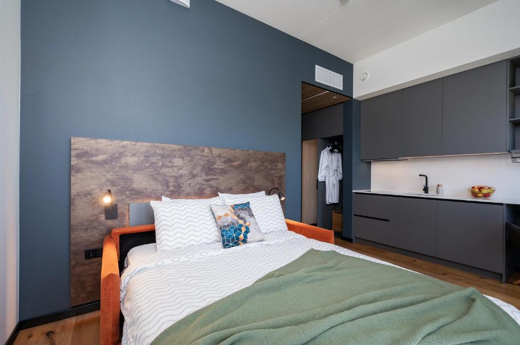 a bedroom with a large bed and a kitchen at New apartment in Karlova in Tartu