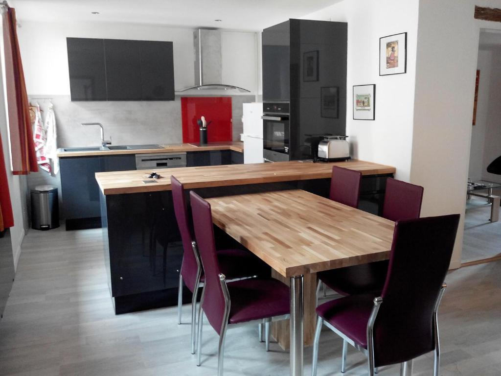 ロウファッハにあるGite duplex du vignoble Alsaceのキッチン(木製テーブル、紫色の椅子付)