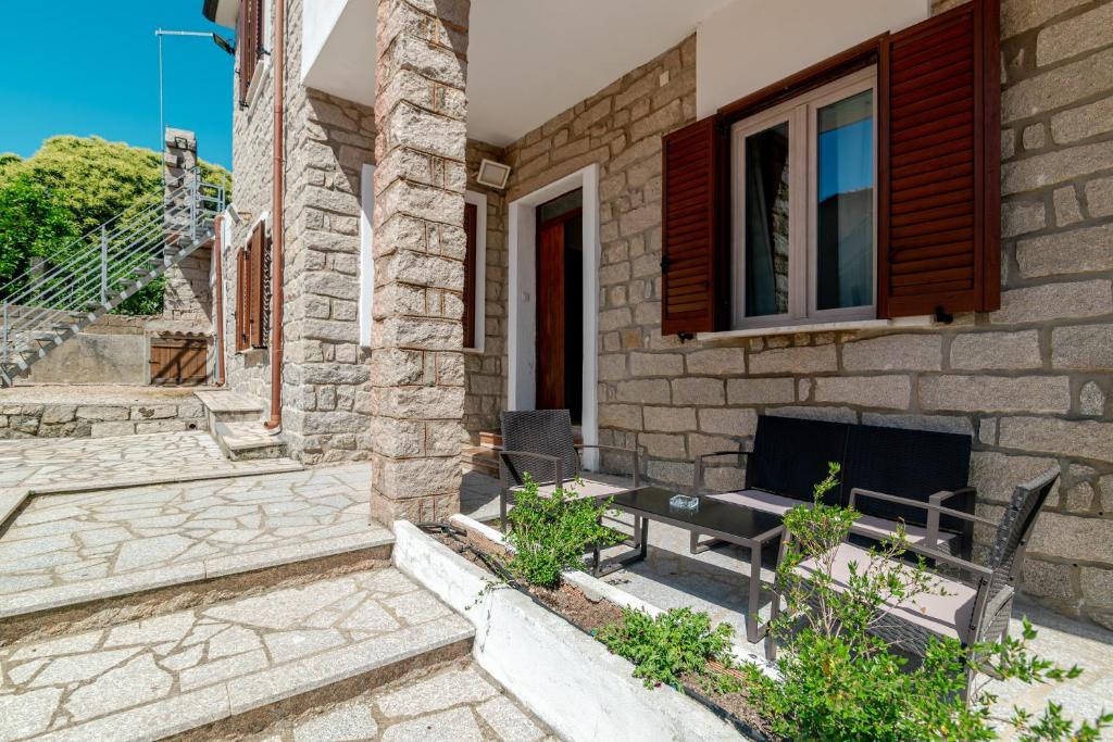 a brick house with a bench and a window at De Addis Guest House in Aggius