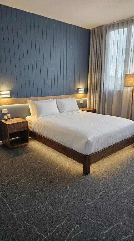 a bedroom with a large bed and a window at ROMSEN Nambucca Valley in Macksville
