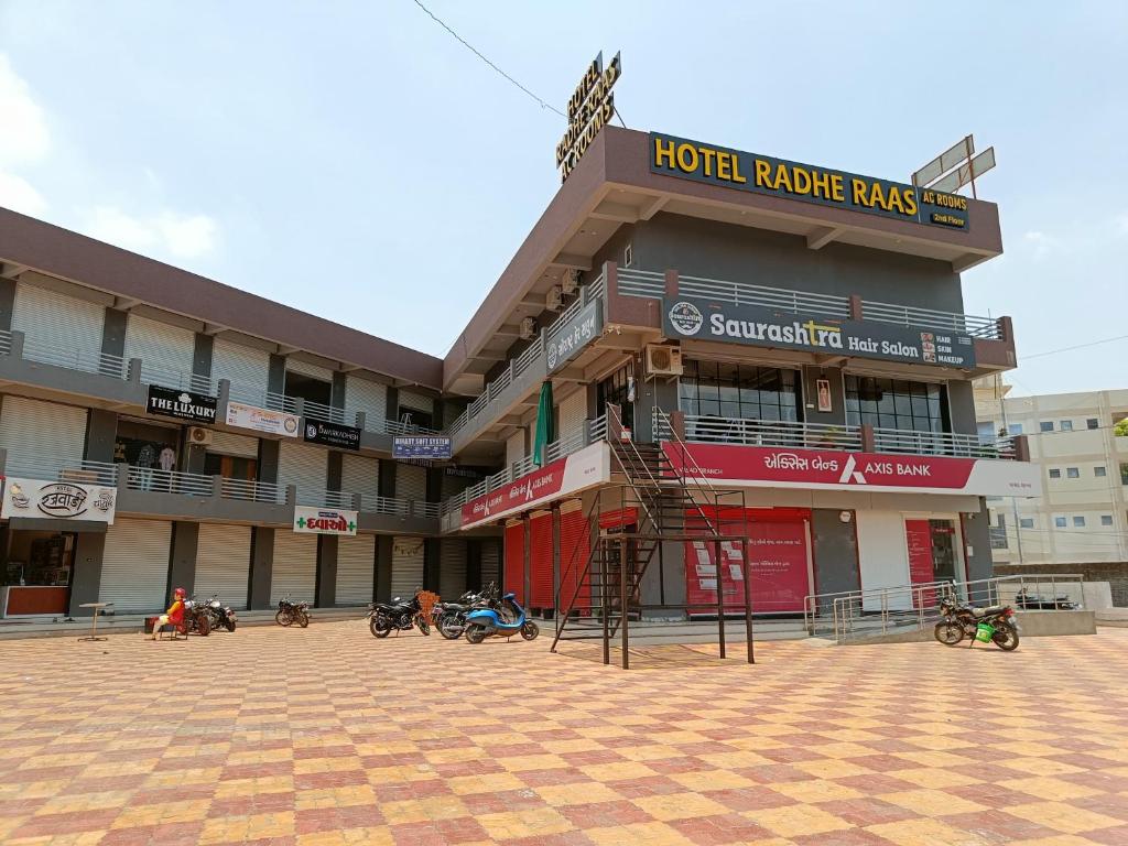 a hotel building with people sitting outside of it at Hotel Radhe Raas in Vāsad