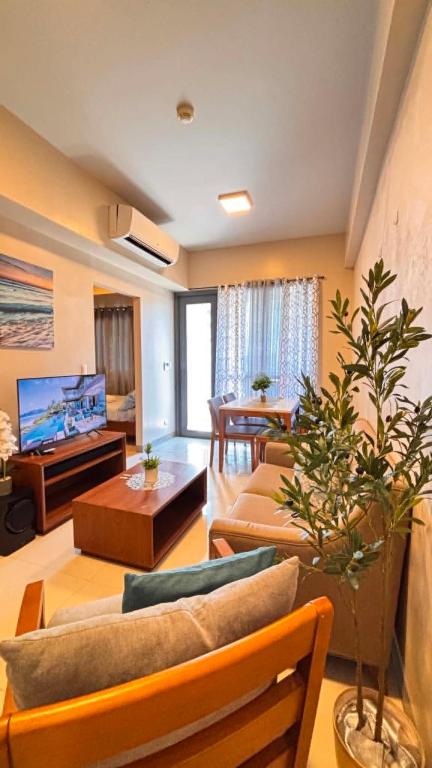 a living room with two couches and a tv at The Mactan Newtown in Punta Engaño