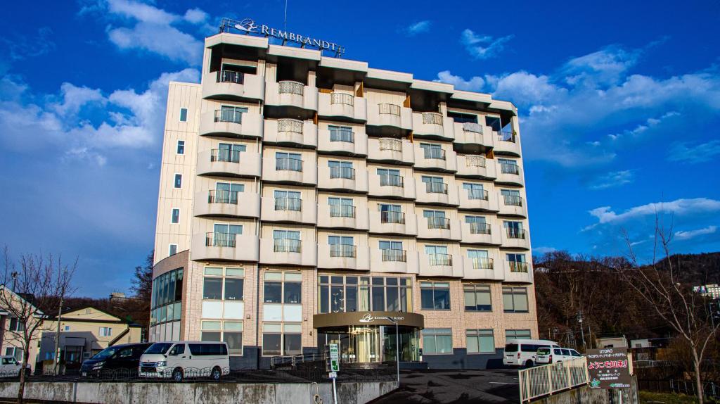 a tall building with cars parked in front of it at Rembrandt Resort Shiretoko in Shari