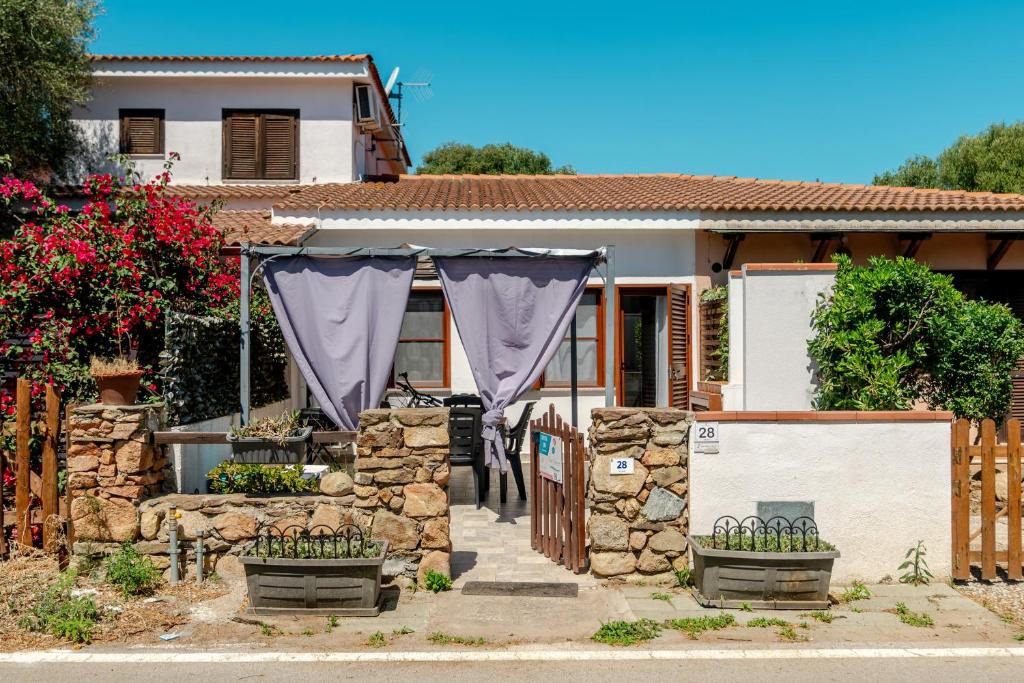 a house with a purple curtain in front of a fence at San Teodoro Monti22 vicino spiaggia in San Teodoro