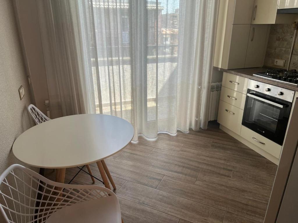 a small kitchen with a white table and a window at Cozy corner Komitas in Yerevan