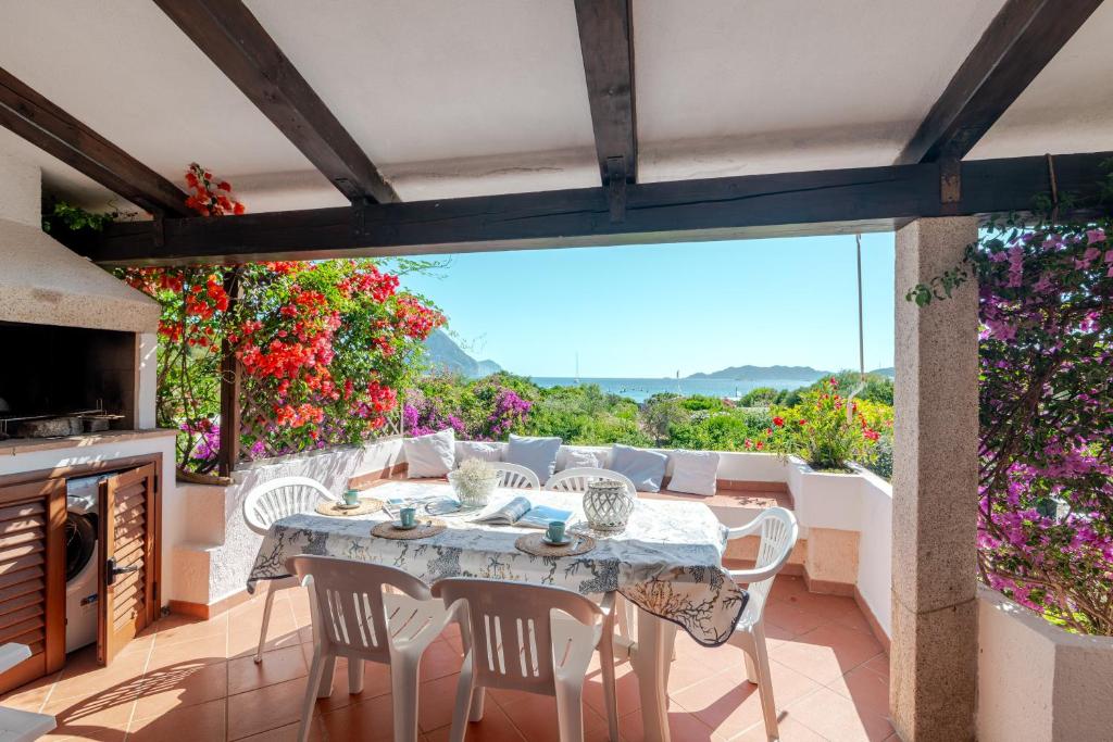 a patio with a table and chairs and flowers at Trilocale Taverna 80 mt spiaggia in Porto Taverna