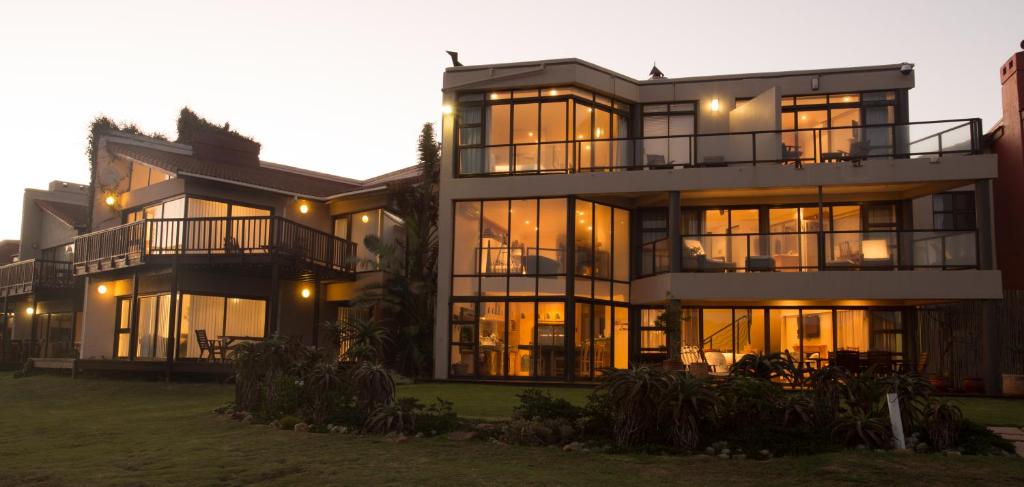 a large building with many windows at dusk at Supertubes Guesthouse in Jeffreys Bay