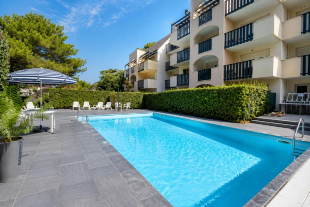 a swimming pool in front of a building at Pool 3 Balconies & Parking in La Baule