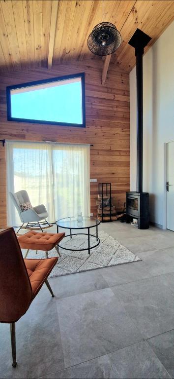 a living room with a table and a fireplace at Pinéa Lodge - Chalet Authentique en Pin des Landes in Saint-Yaguen