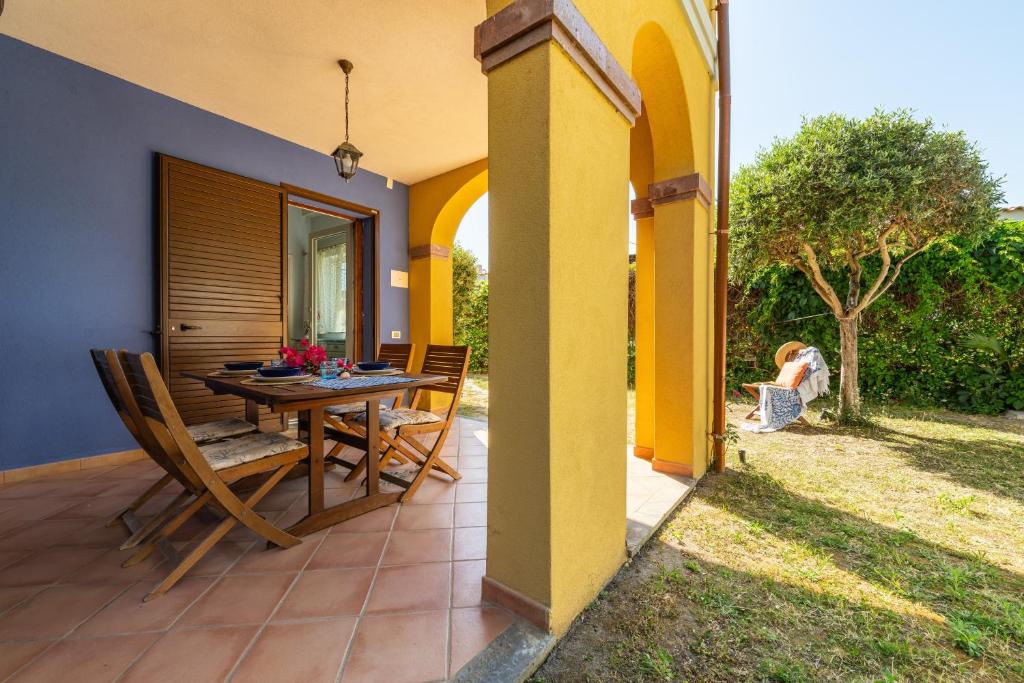 a patio with a wooden table and chairs at Alloggio Nettuno in Villasimius