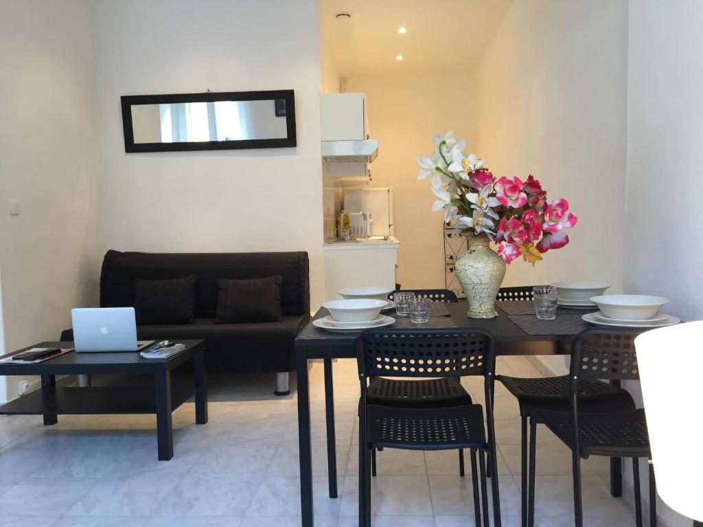 a dining room with a table with chairs and a laptop at Appartement Euromed - Les Docks in Marseille