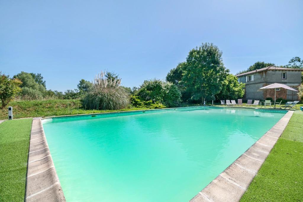 a large blue swimming pool in a yard at Domaine De Bellerose in Cadeillan