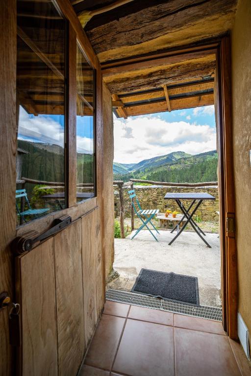 an open door to a patio with a table at Sons do Eo- Apartamentos rurales sostenibles en Baleira Lugo in Baleira