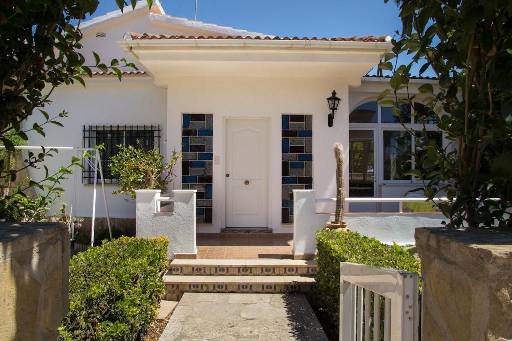 a white house with a white door and a gate at Villa Mª José in Benicarló