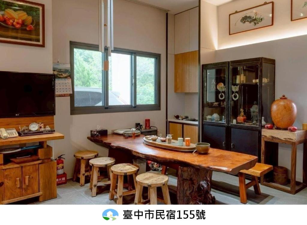 a kitchen with a large wooden table and stools at 山禾湖畔 in Xinshe