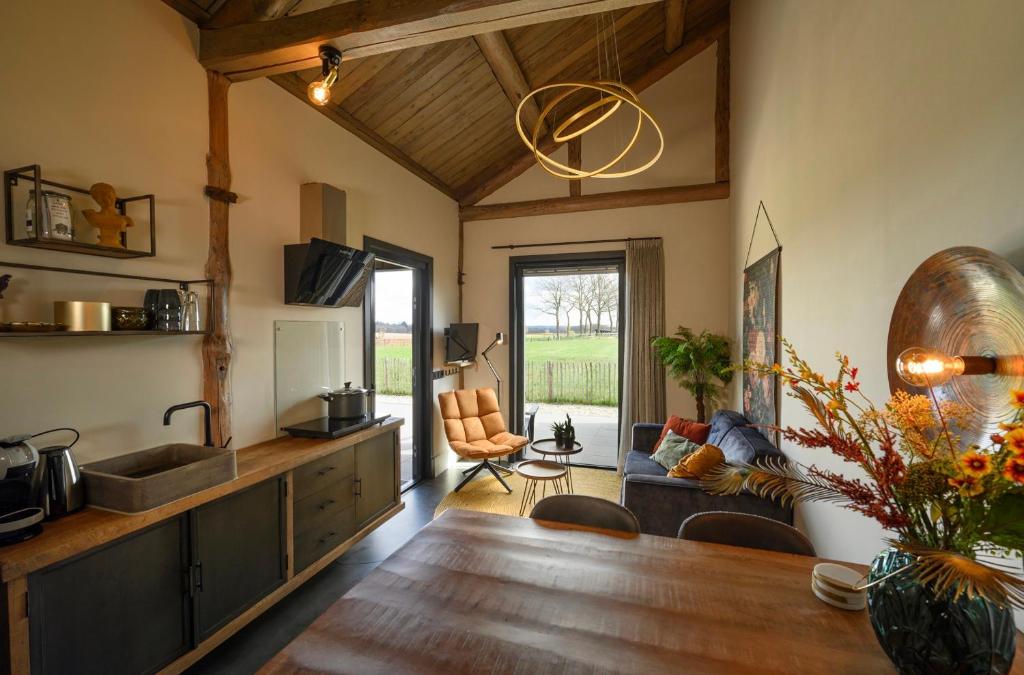 a kitchen and living room with a wooden table at Onder de Molen in Garderen