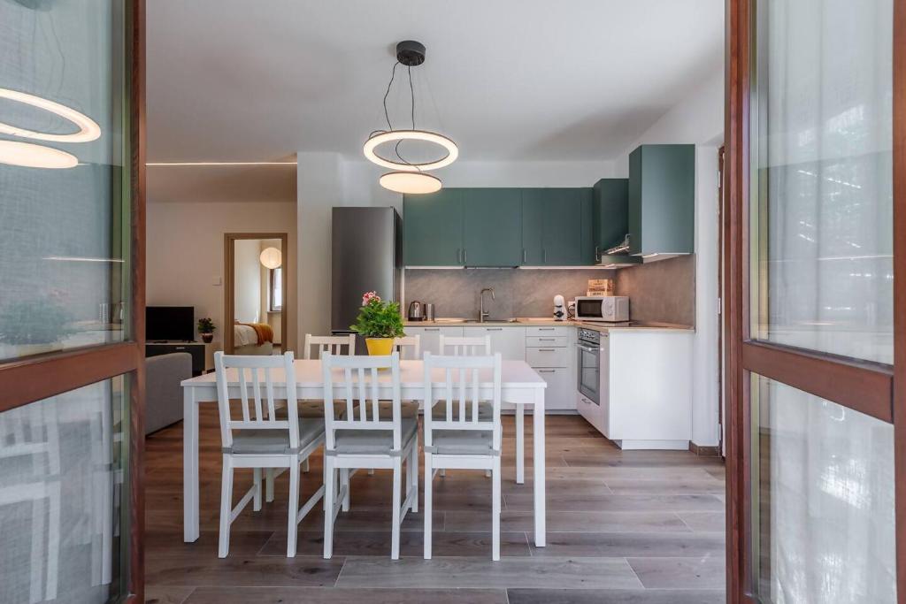 a kitchen with a white table and white chairs at Maison Bovet Appartements in Arvier