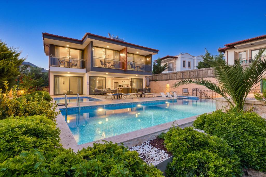 a large house with a swimming pool in front of it at VILLA ALKIM in Kaş