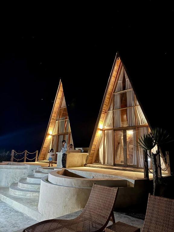 a building with two triangular roofs at night at Volcano Side Kintamani Bali in Kintamani