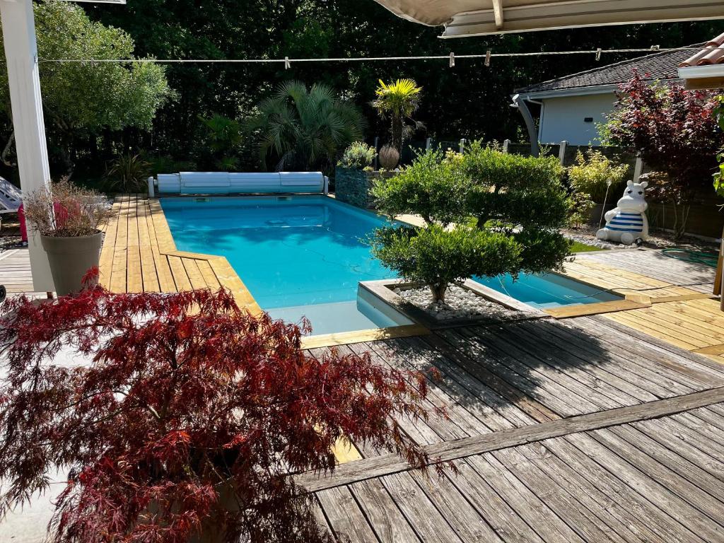 a swimming pool in a yard with a wooden deck at La maisonnette de chez Pascalou in Lège-Cap-Ferret